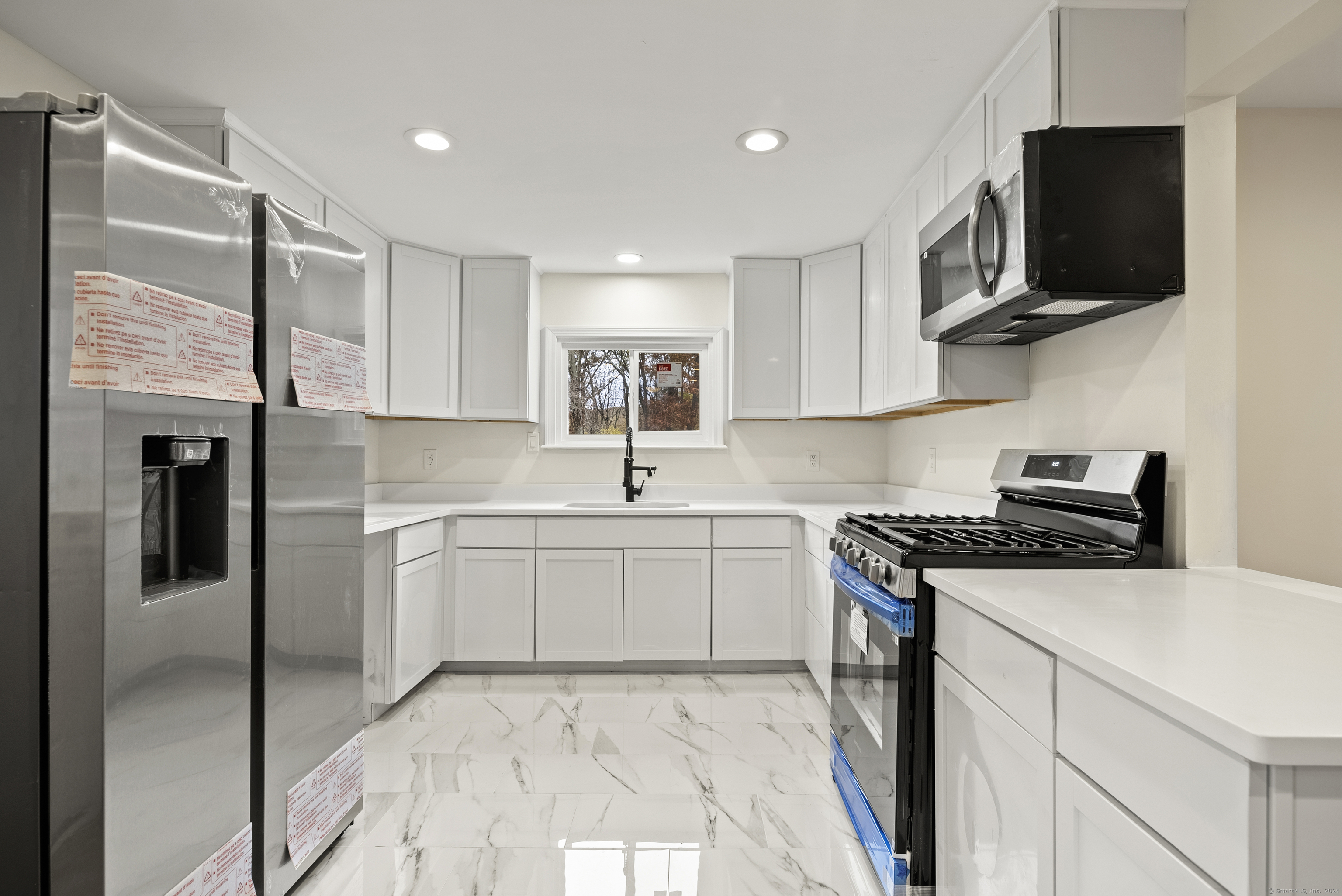 a kitchen with a sink stainless steel appliances and cabinets