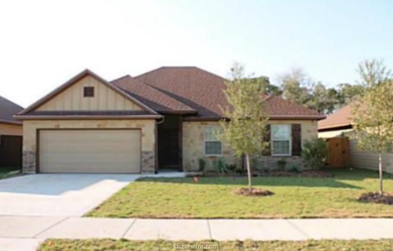 Single story home with a garage and a front lawn