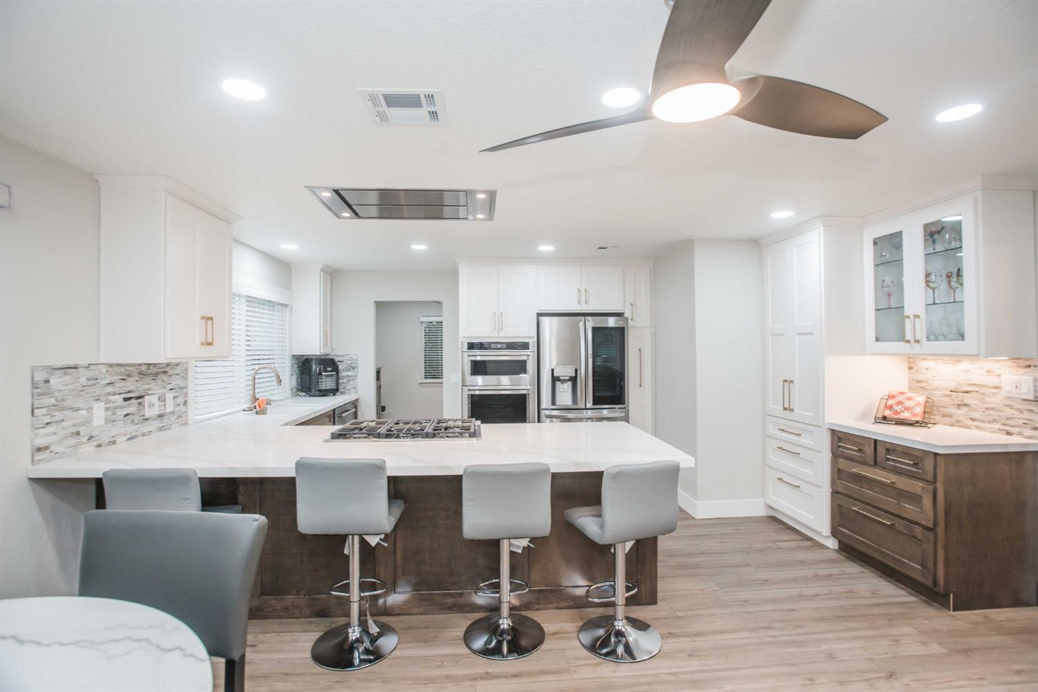 a view of kitchen with stainless steel appliances kitchen island dining table and chairs