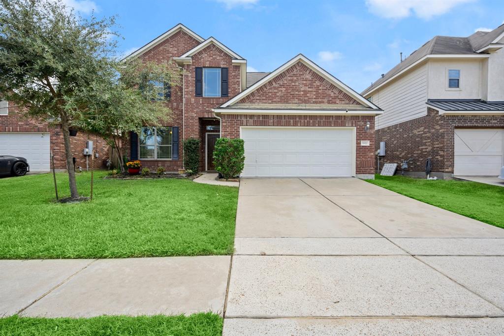 a front view of a house with a yard and garage