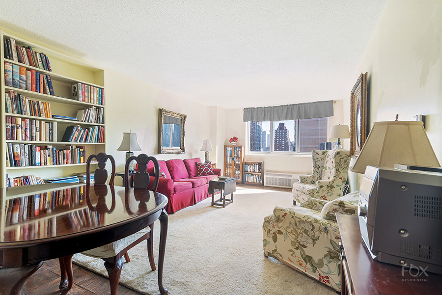 a living room with furniture and a book shelf