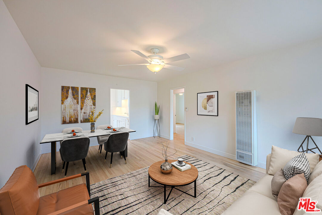 a living room with furniture a rug and wall paintings