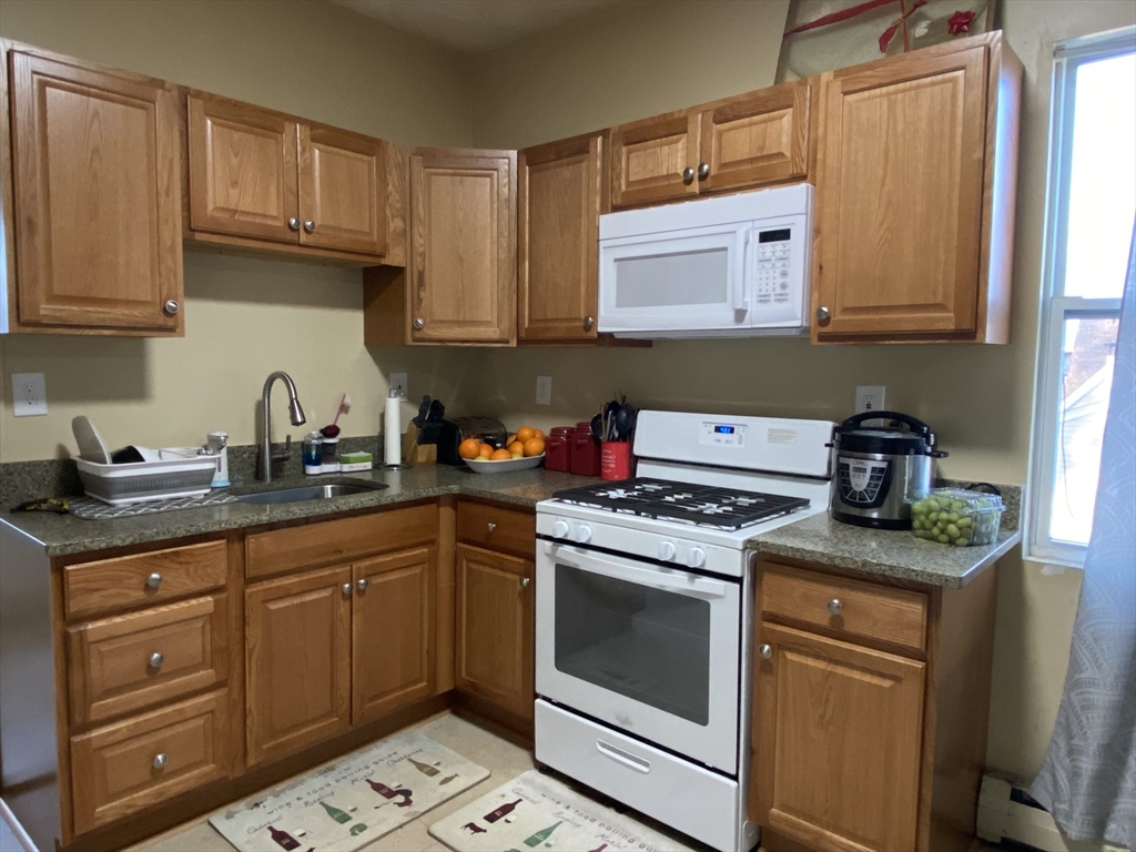 a kitchen with cabinets appliances a sink and a counter space