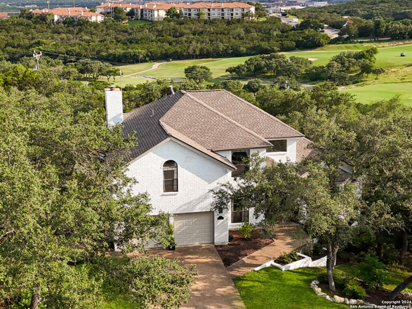 an aerial view of a house with yard and green space