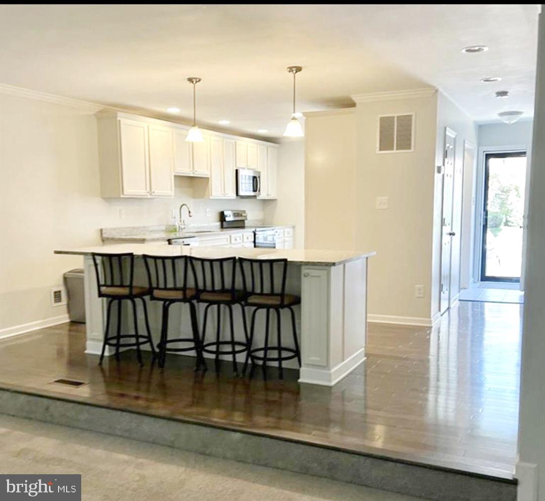 a kitchen with kitchen island a dining table chairs and a wooden floor