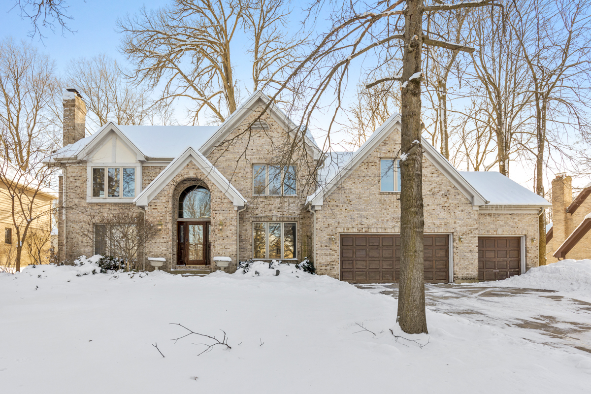 a front view of a house with a yard covered in snow