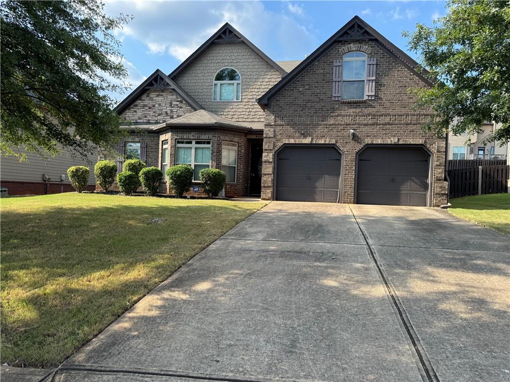 a front view of a house with a yard and garage