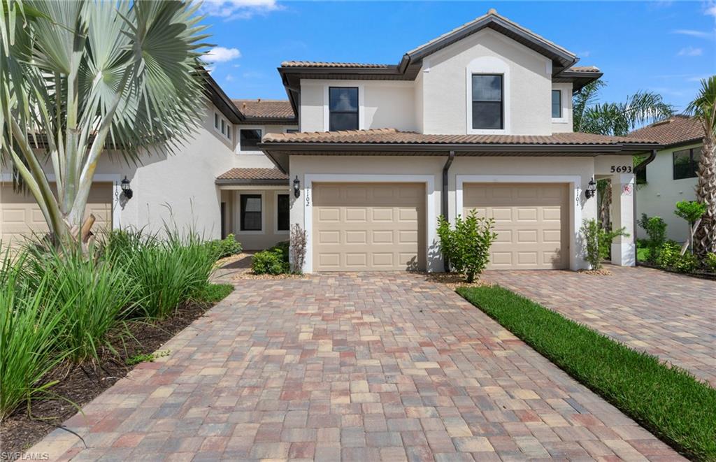 a front view of a house with a yard and a garage