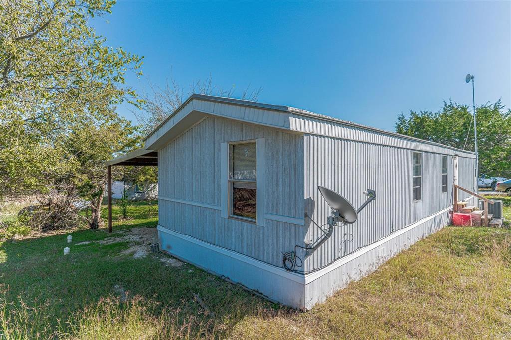 a view of backyard with small cabin and wooden fence