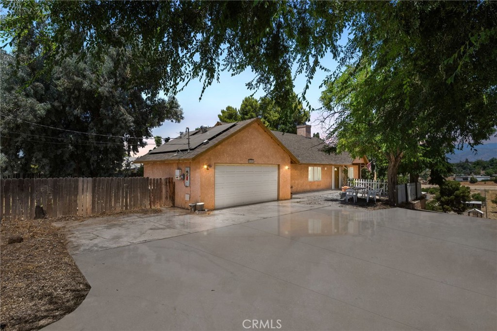 a view of a house with a yard and large tree