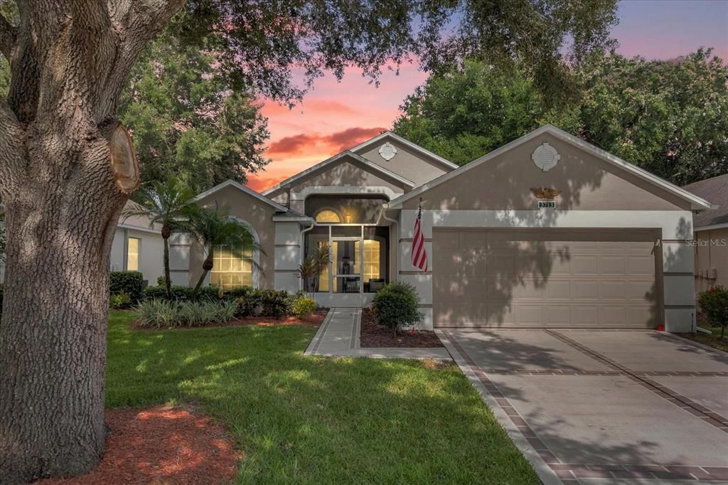 a front view of a house with a yard and trees