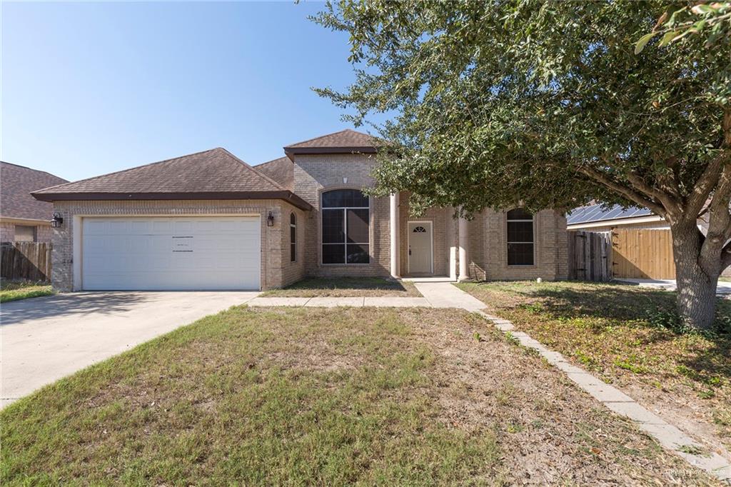 View of front of home with a front yard and a garage