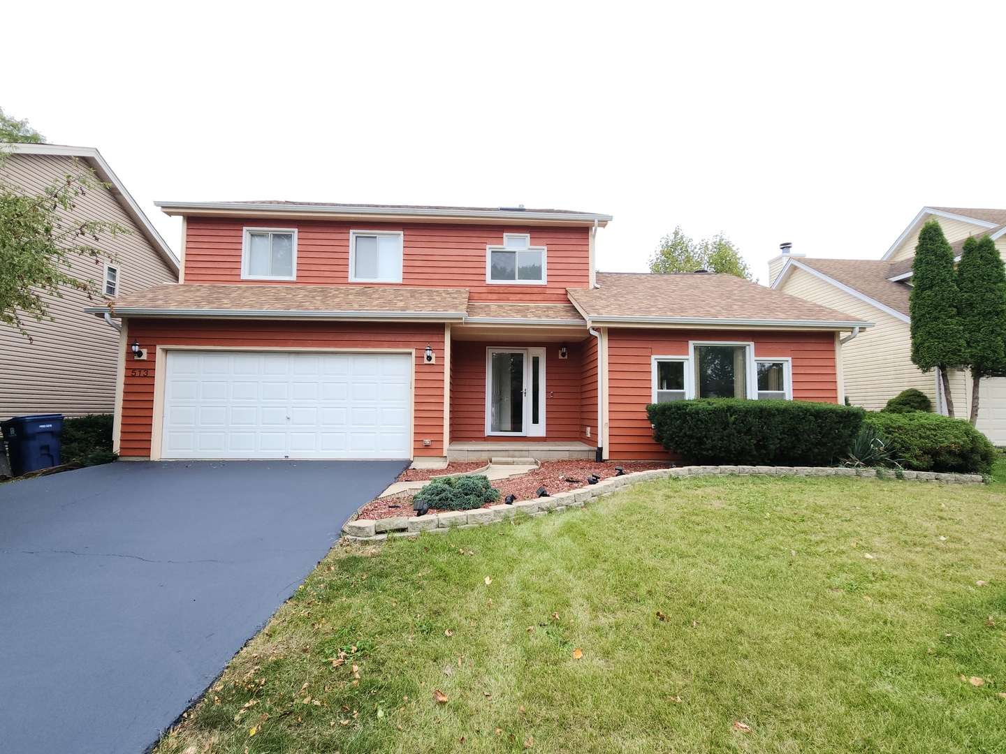 a front view of a house with a yard and garage