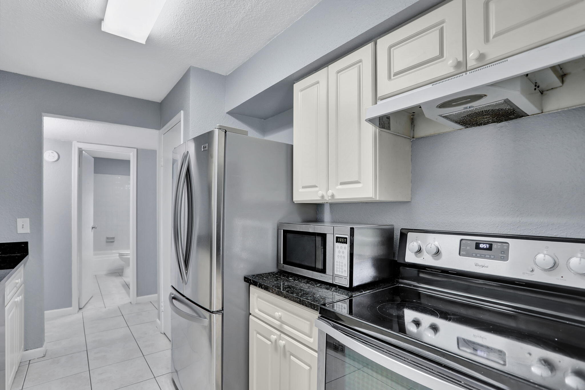 a kitchen with stainless steel appliances granite countertop a refrigerator and a stove