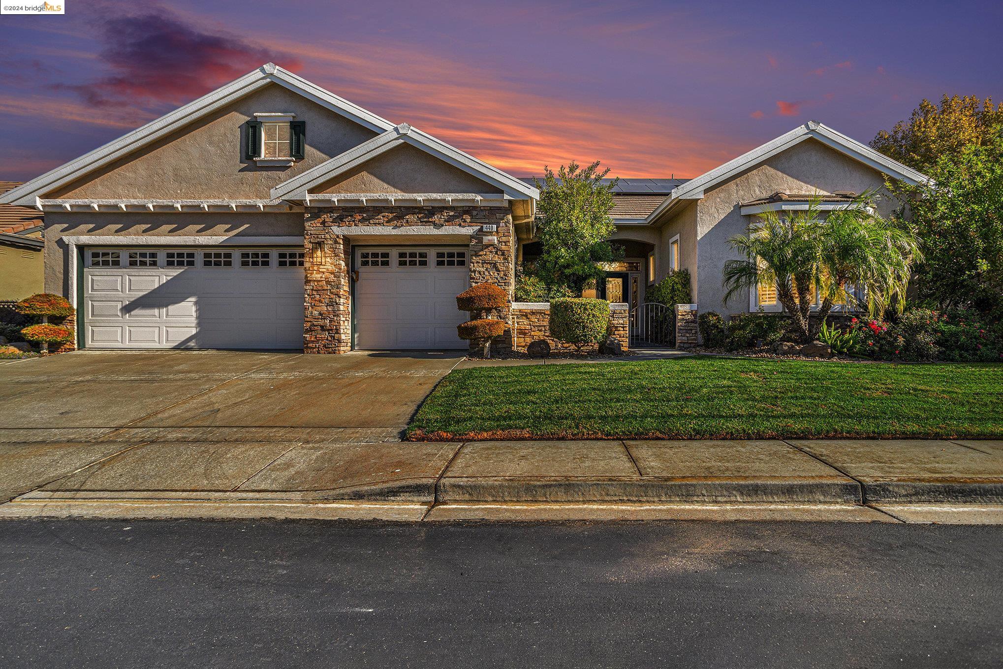 a front view of a house with a garden and a garage