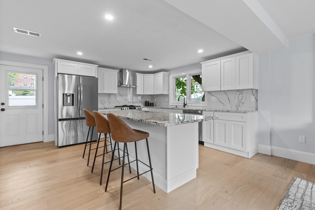 a kitchen with white cabinets stainless steel appliances and a window