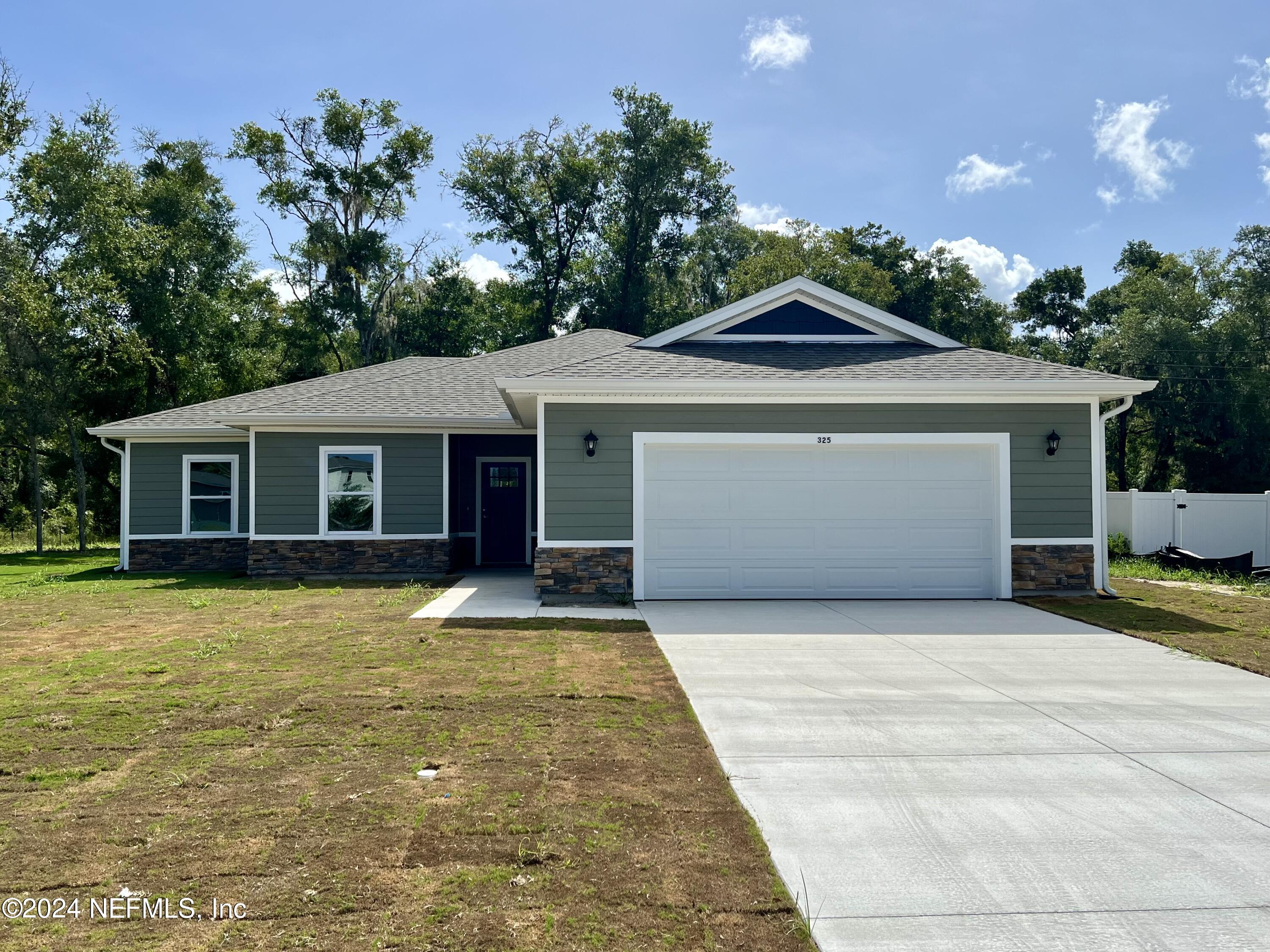 a front view of a house with yard and garage