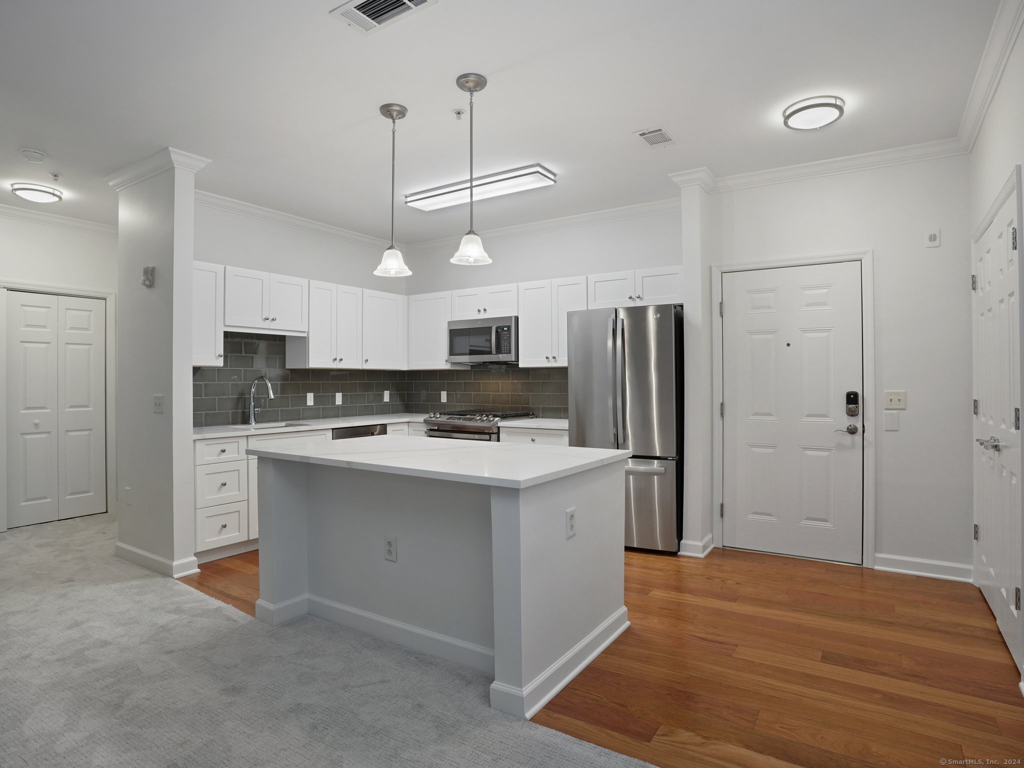 a kitchen with kitchen island a sink stainless steel appliances and cabinets