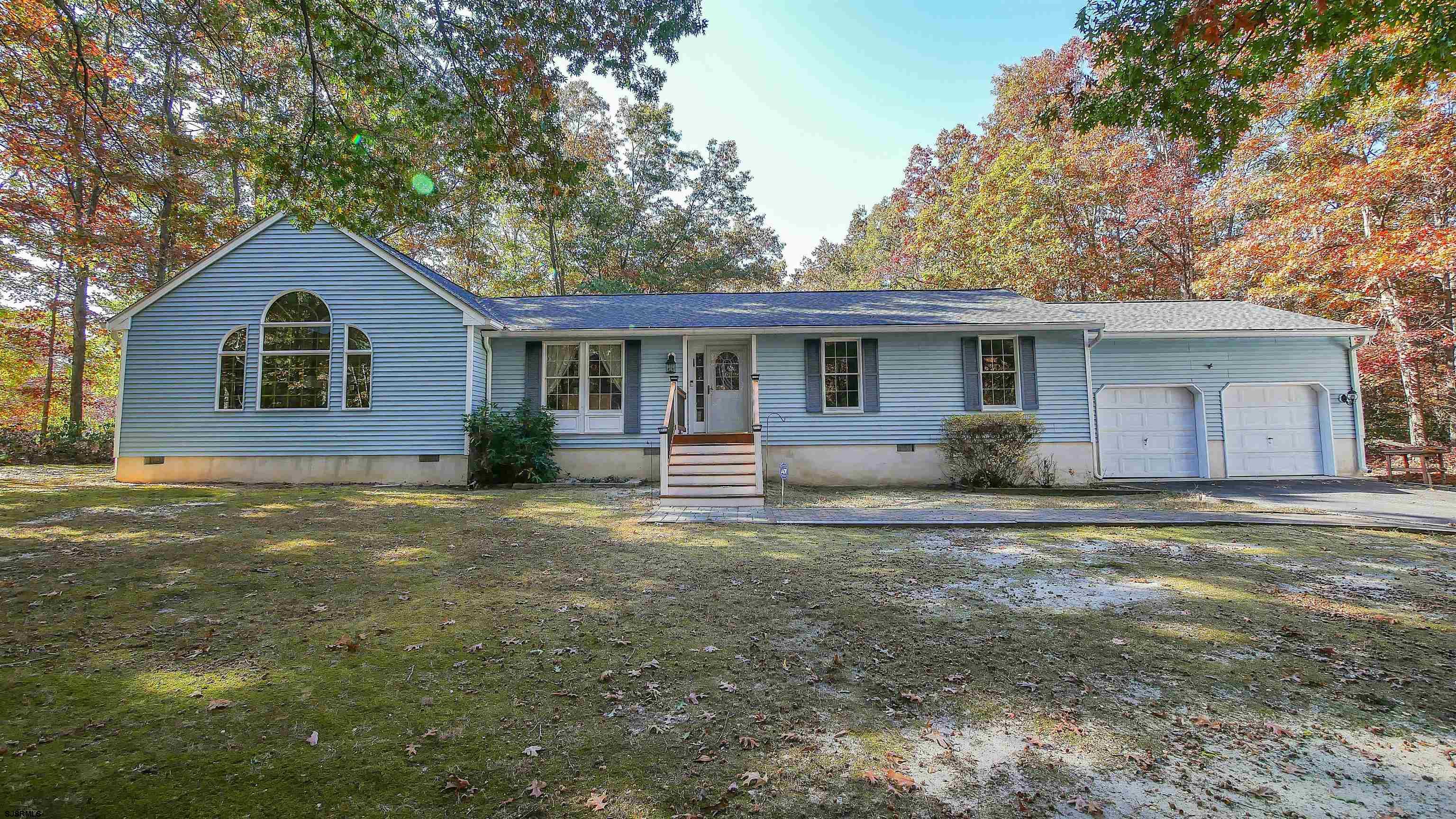 a front view of house with yard and trees around