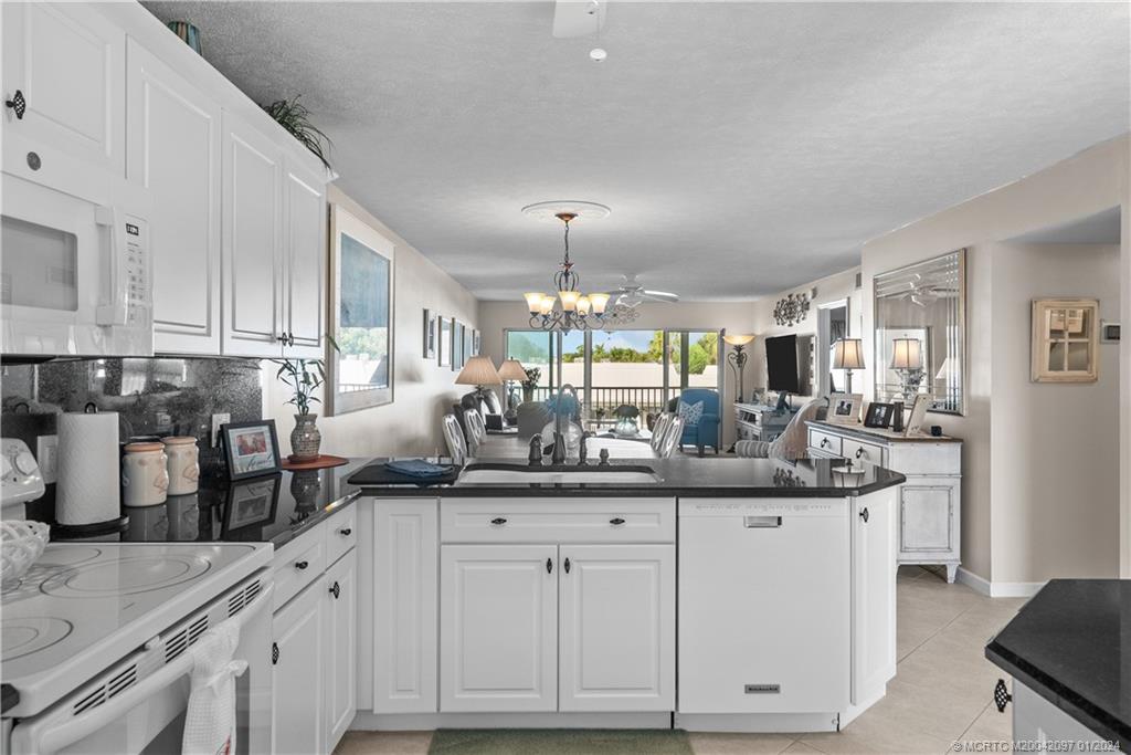 a kitchen with white cabinets and sink