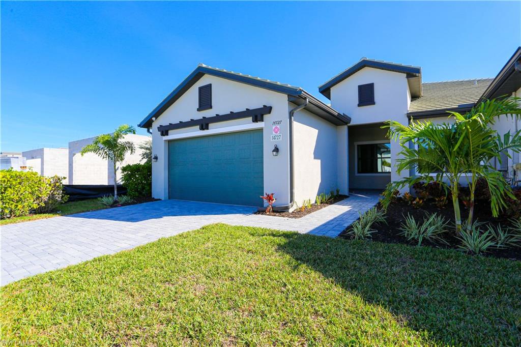 View of front of home with a garage and a front yard