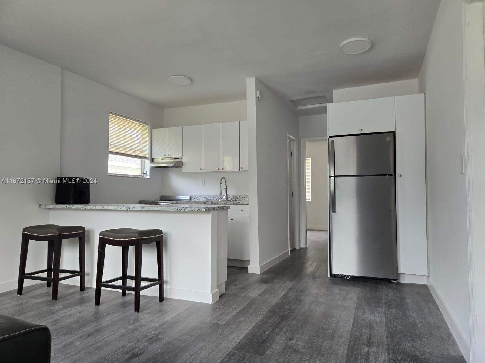 a kitchen with a refrigerator and a stove top oven