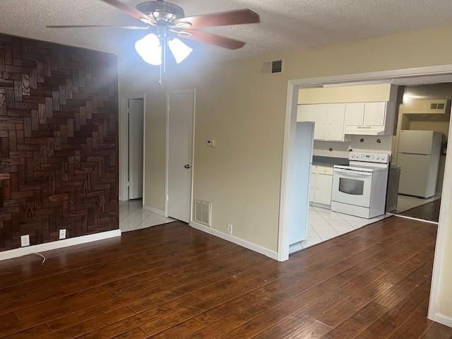 a view of a kitchen with wooden floor electronic appliances and cabinets