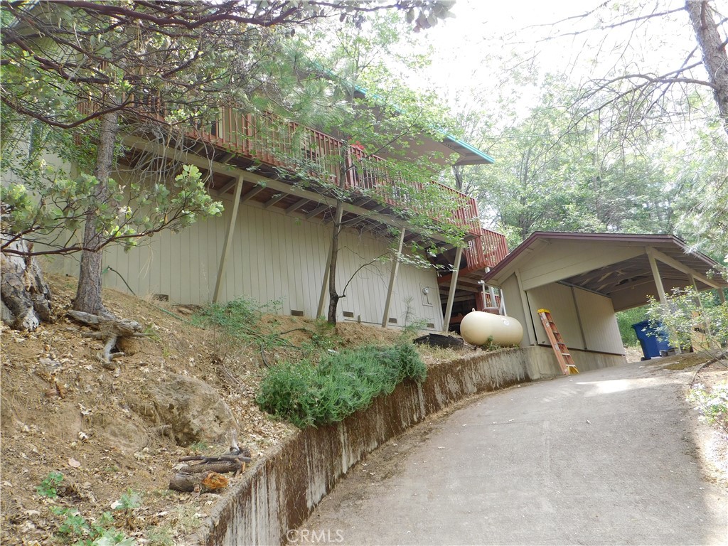 a backyard of a house with table and chairs under an umbrella