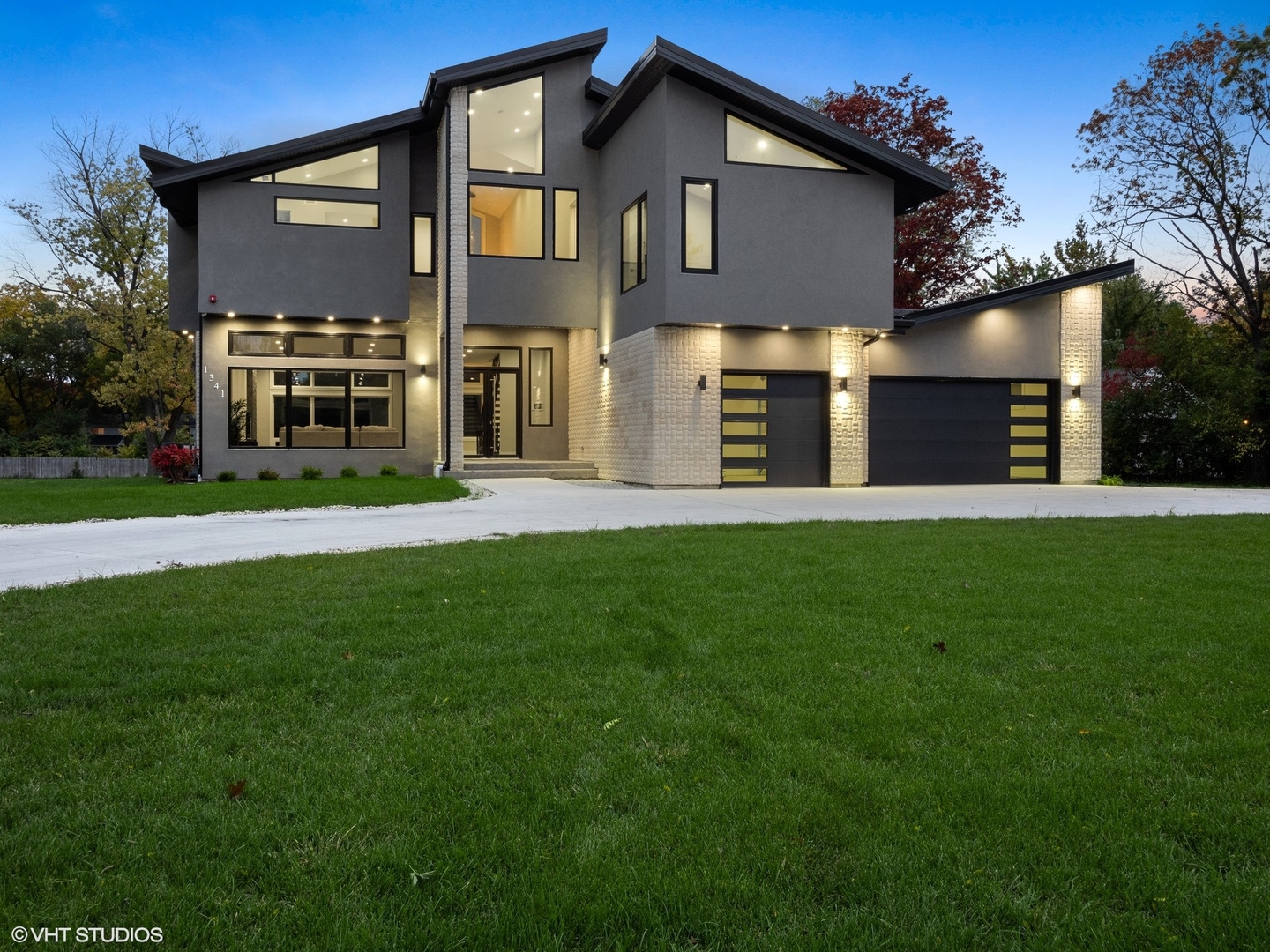 a front view of a house with a yard and trees