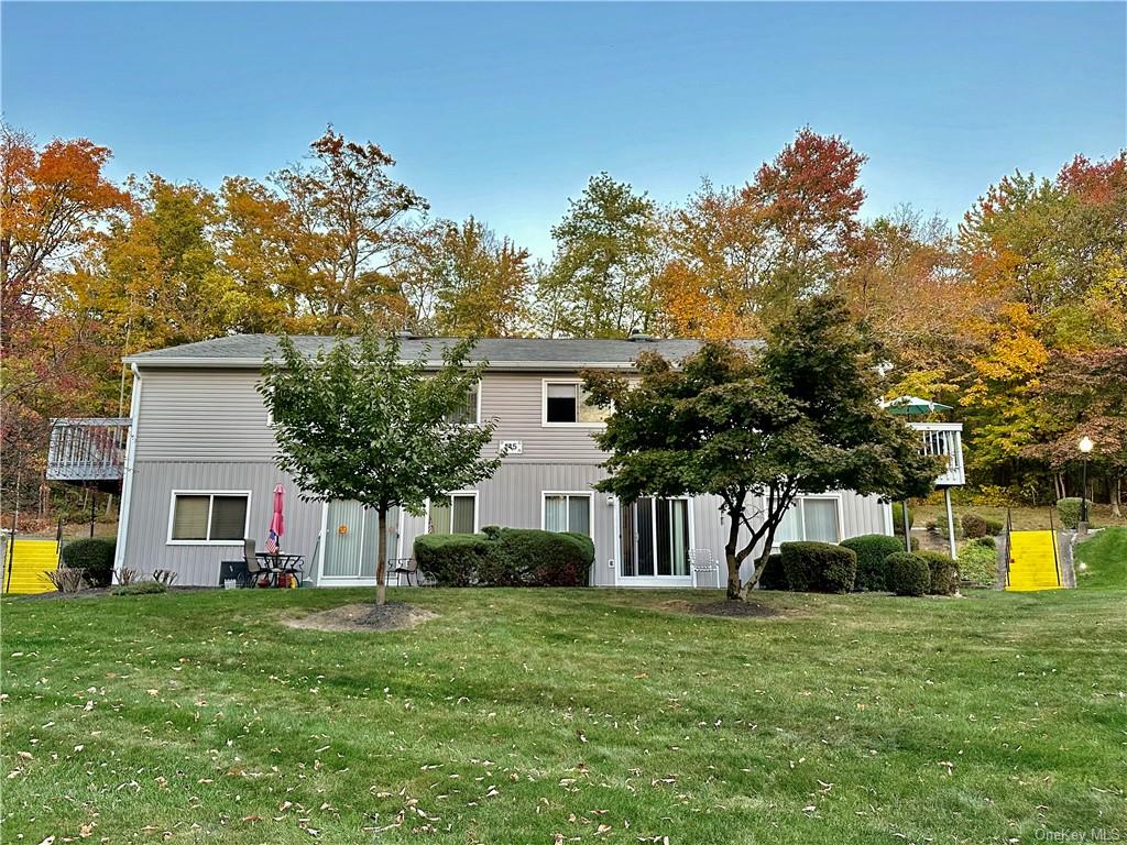 Back of house with a lawn