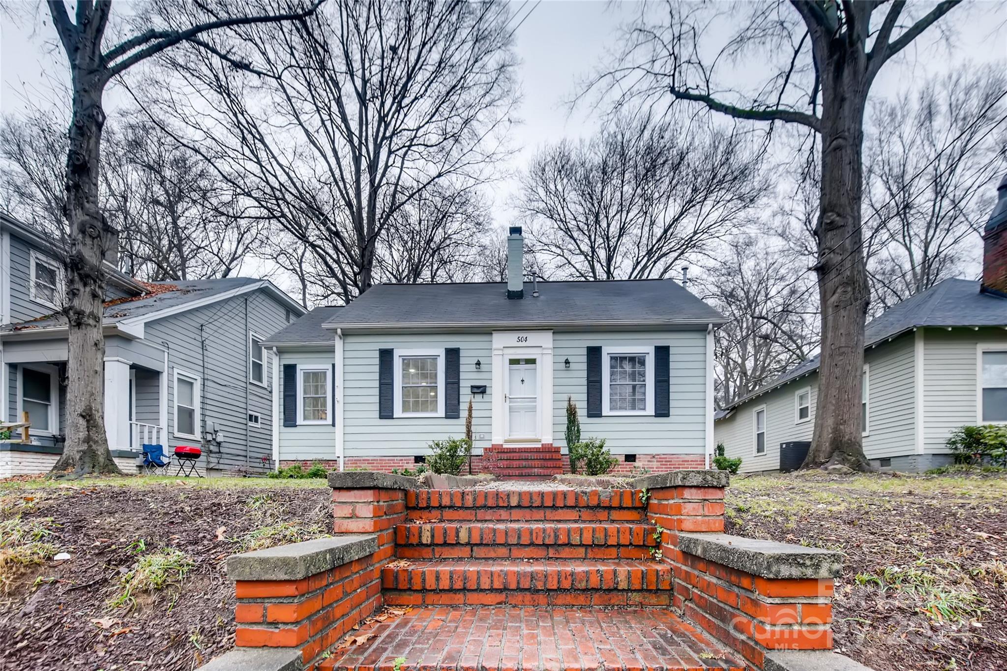 a front view of a house with porch and seating space