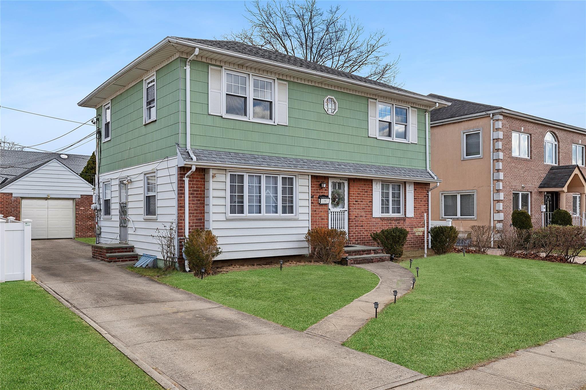 a front view of a house with a yard and trees