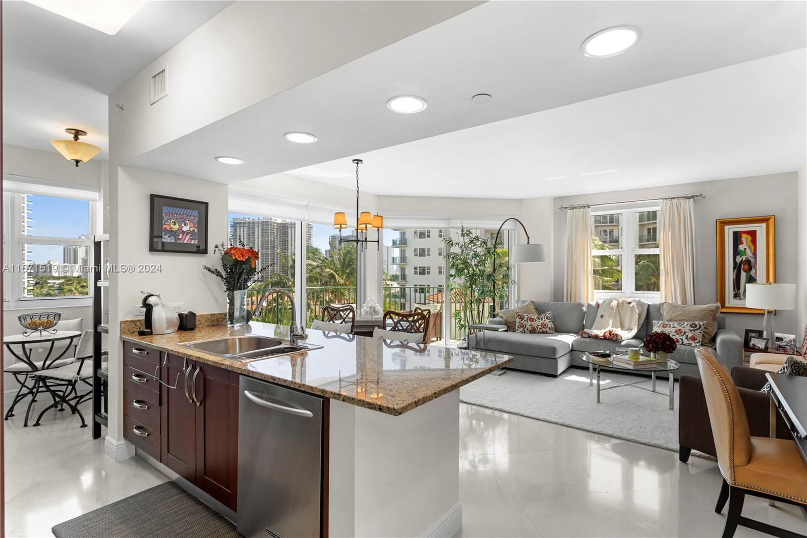 a kitchen with stainless steel appliances granite countertop a sink and a large window