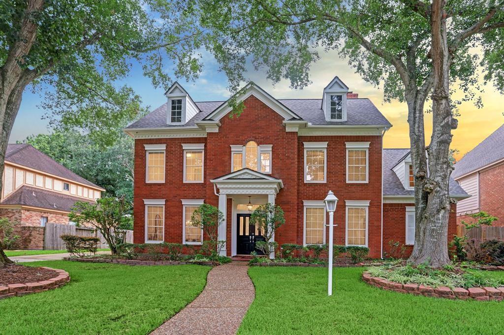 front view of a brick house with a yard