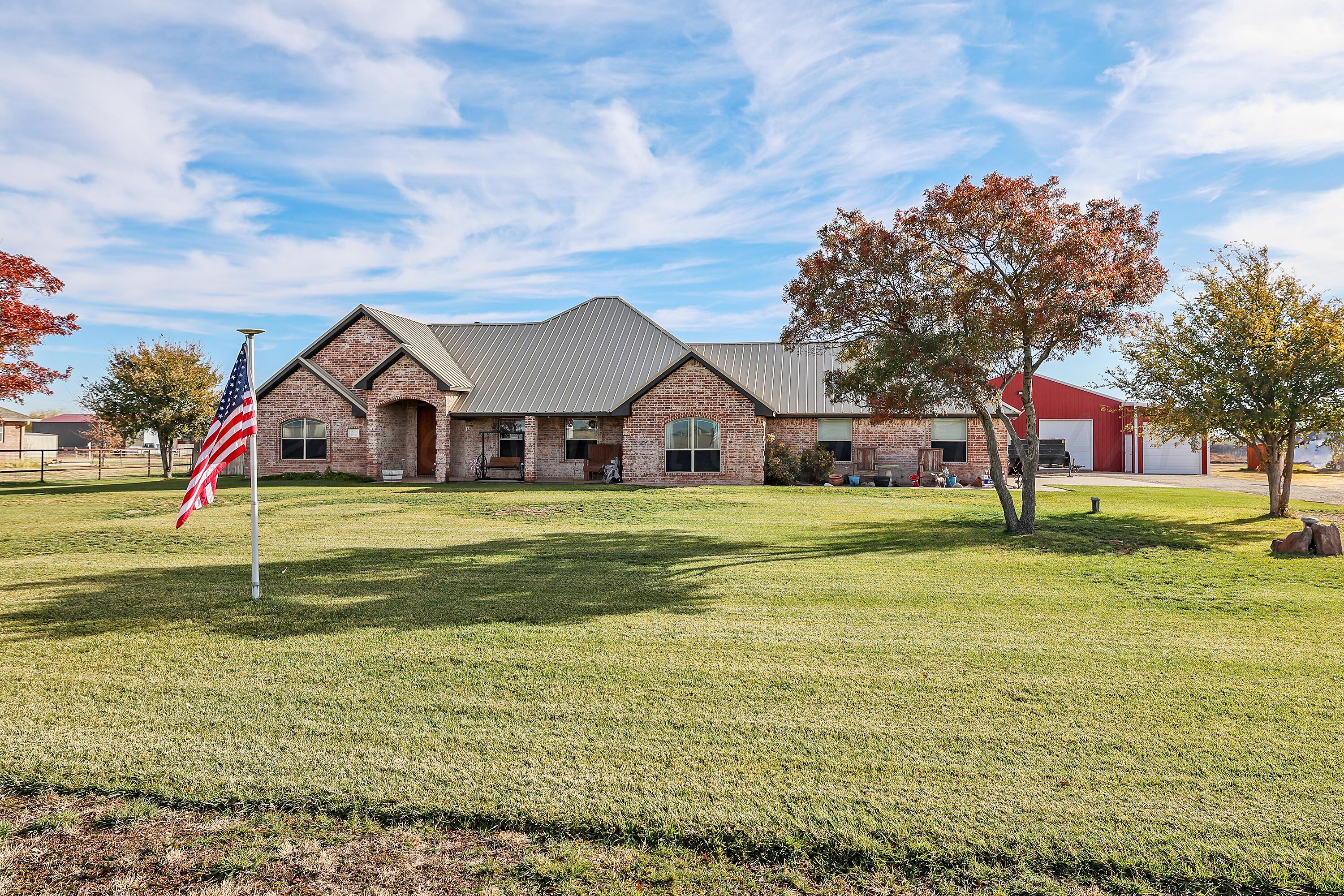 a view of a house with a big yard and large trees