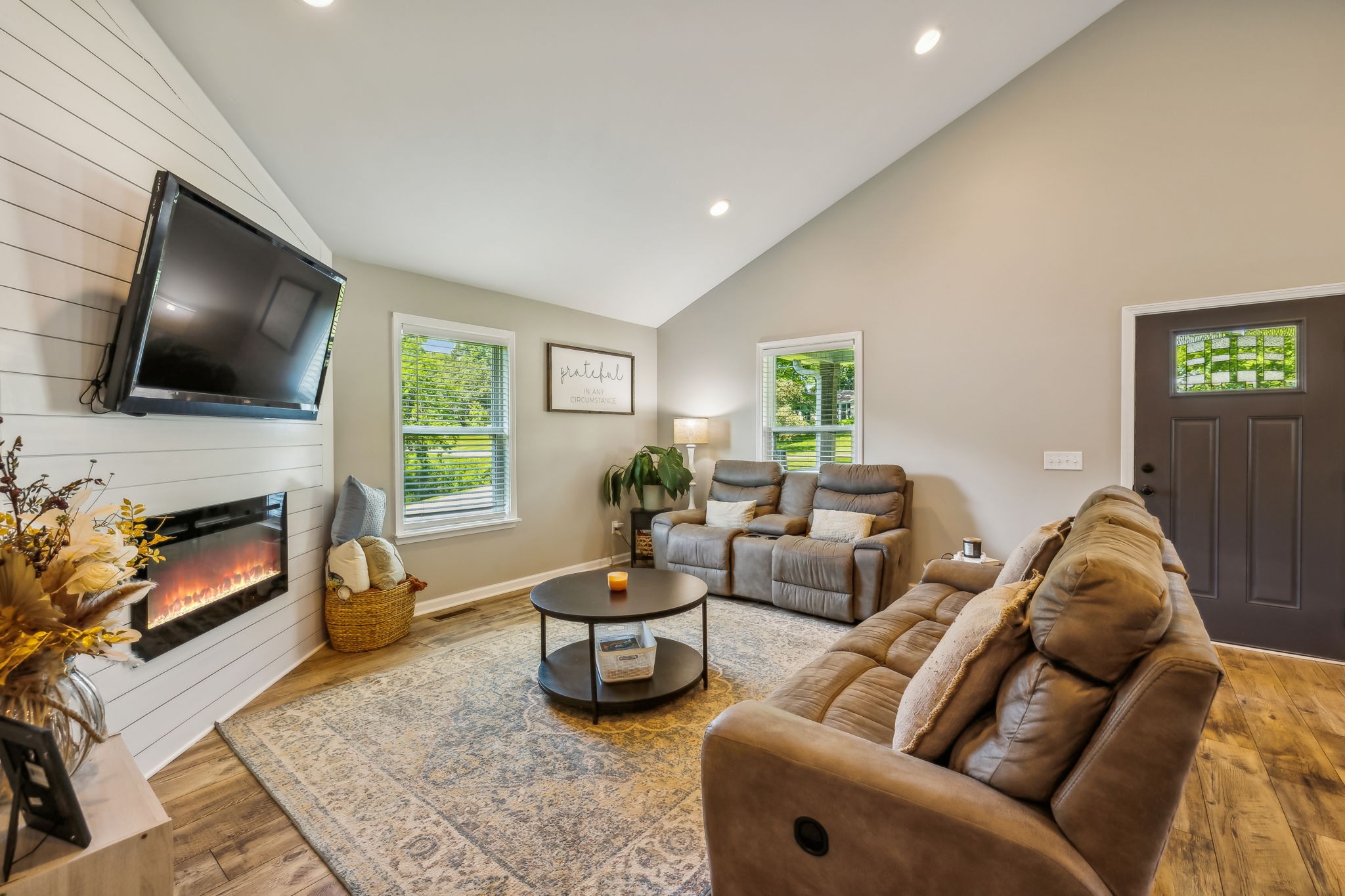 a living room with furniture a fireplace and a flat screen tv