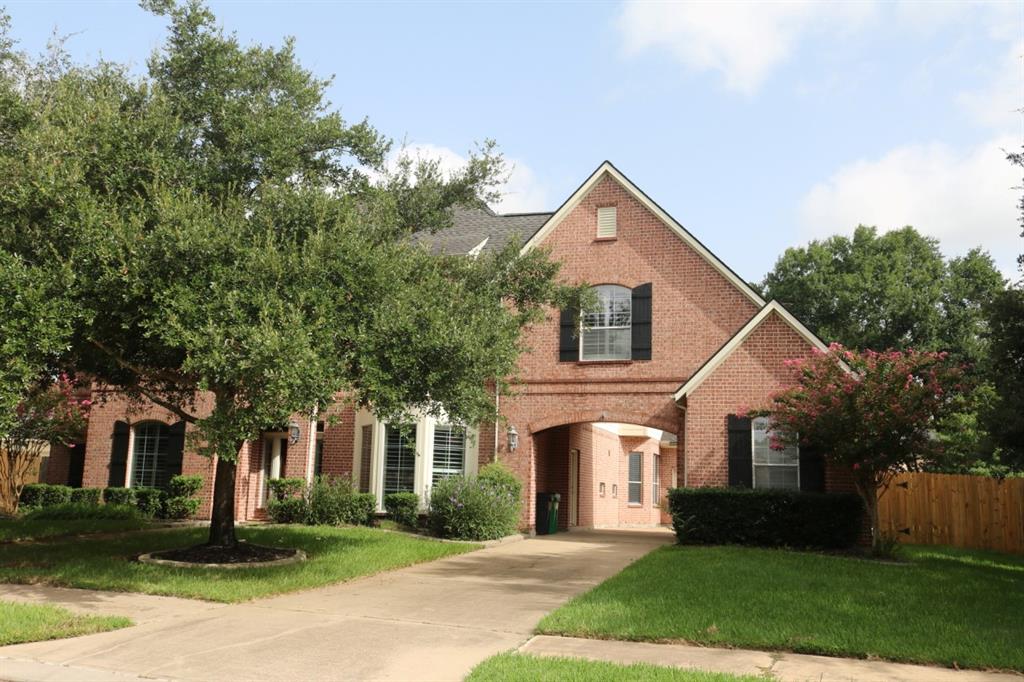 a front view of a house with a yard and trees