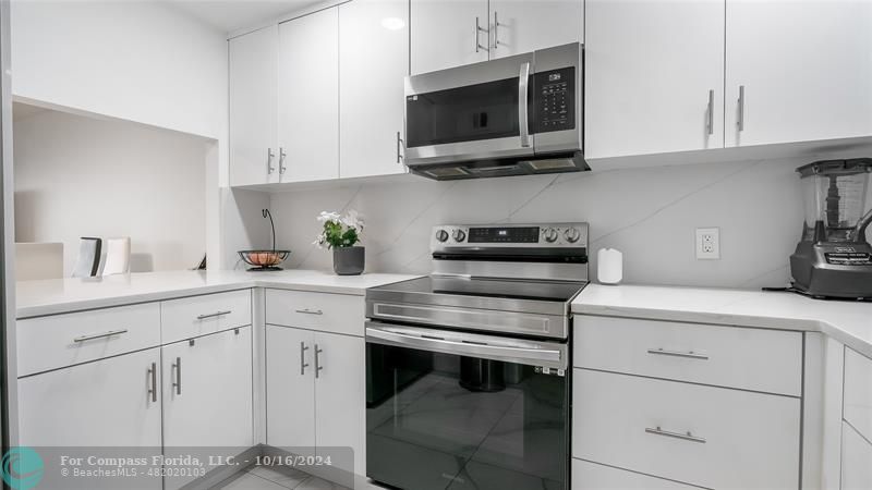 a kitchen with white cabinets stainless steel appliances and sink