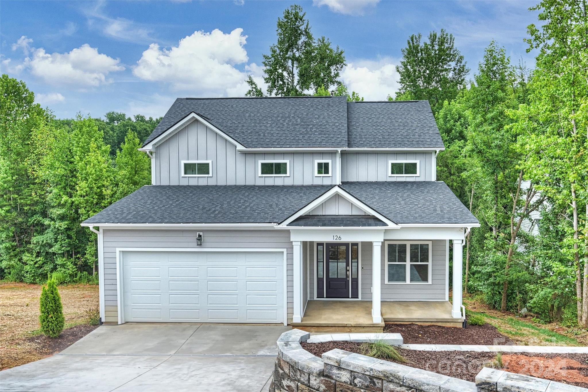 a front view of a house with a garden and garage