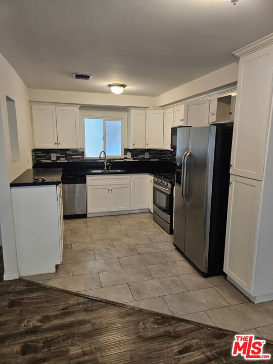 a kitchen with stainless steel appliances granite countertop a refrigerator and a stove