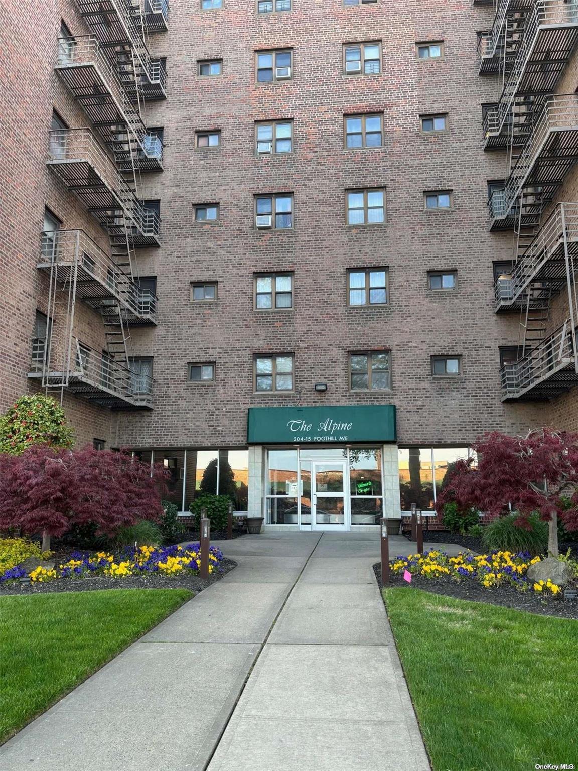 a view of a brick building with many windows and yard