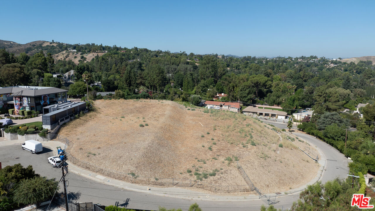 an aerial view of a house with a yard and mountain view