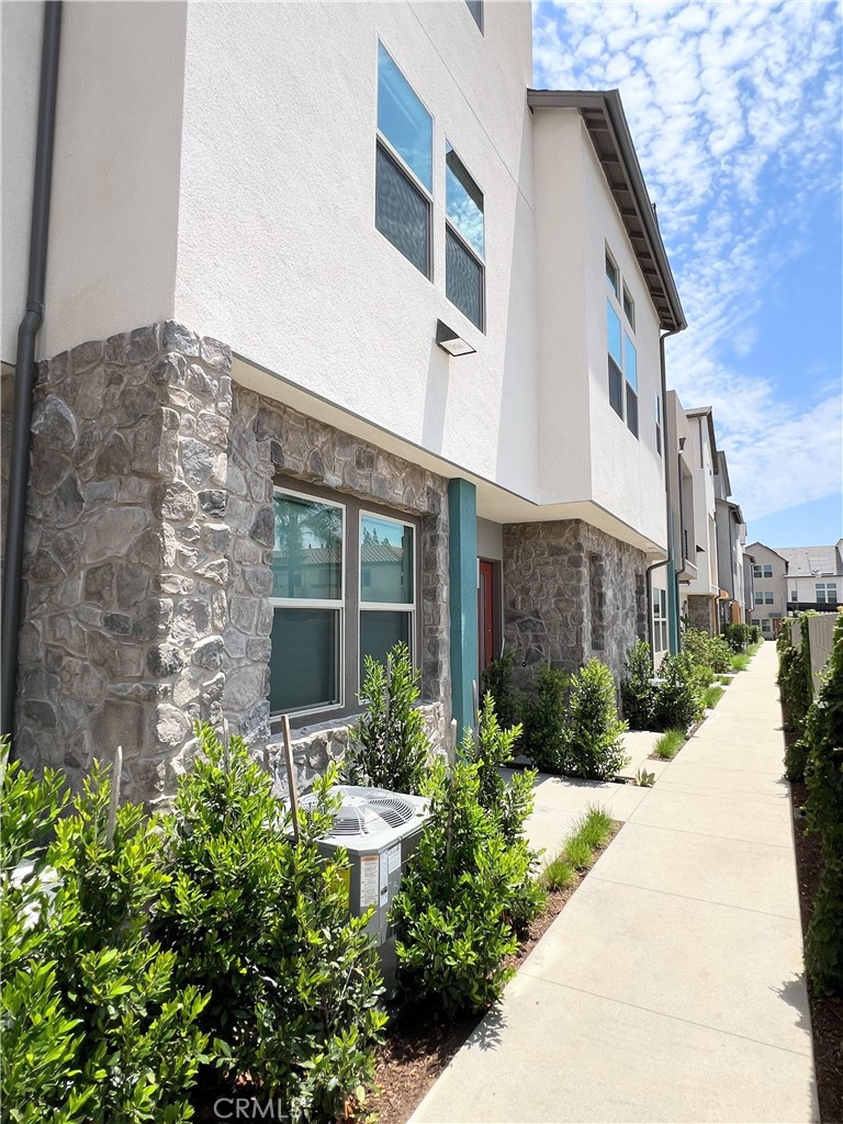 a front view of a multi story residential apartment building with yard and glass windows