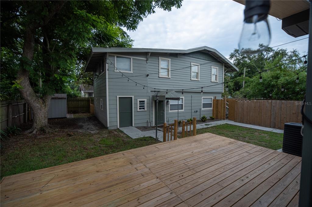 a backyard of a house with table and chairs a barbeque with wooden fence