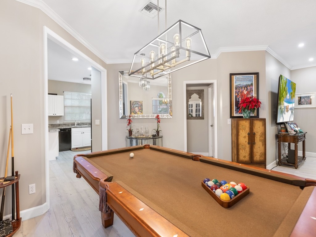 a living room with furniture pool table and kitchen view