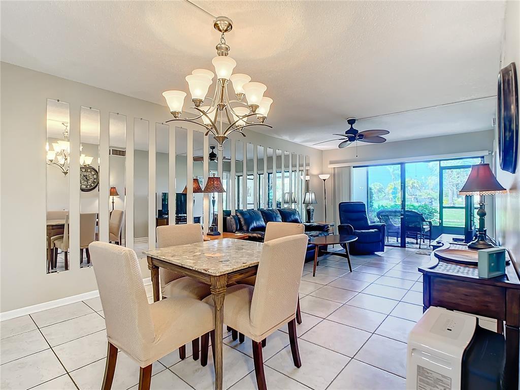 a view of a dining room with furniture a chandelier and large window