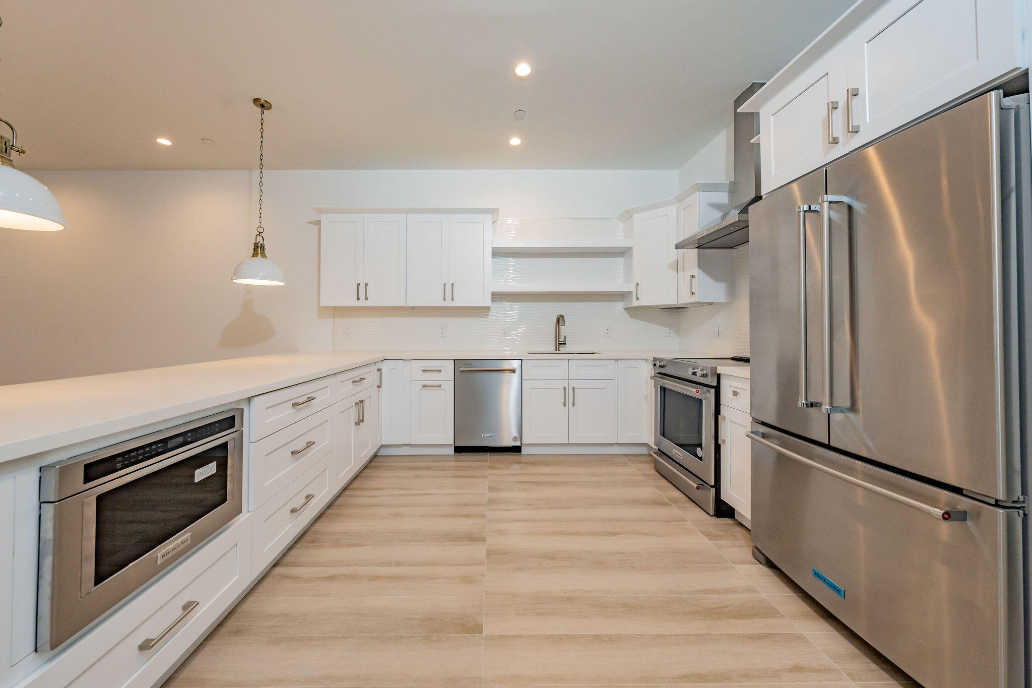 a kitchen with white cabinets stainless steel appliances