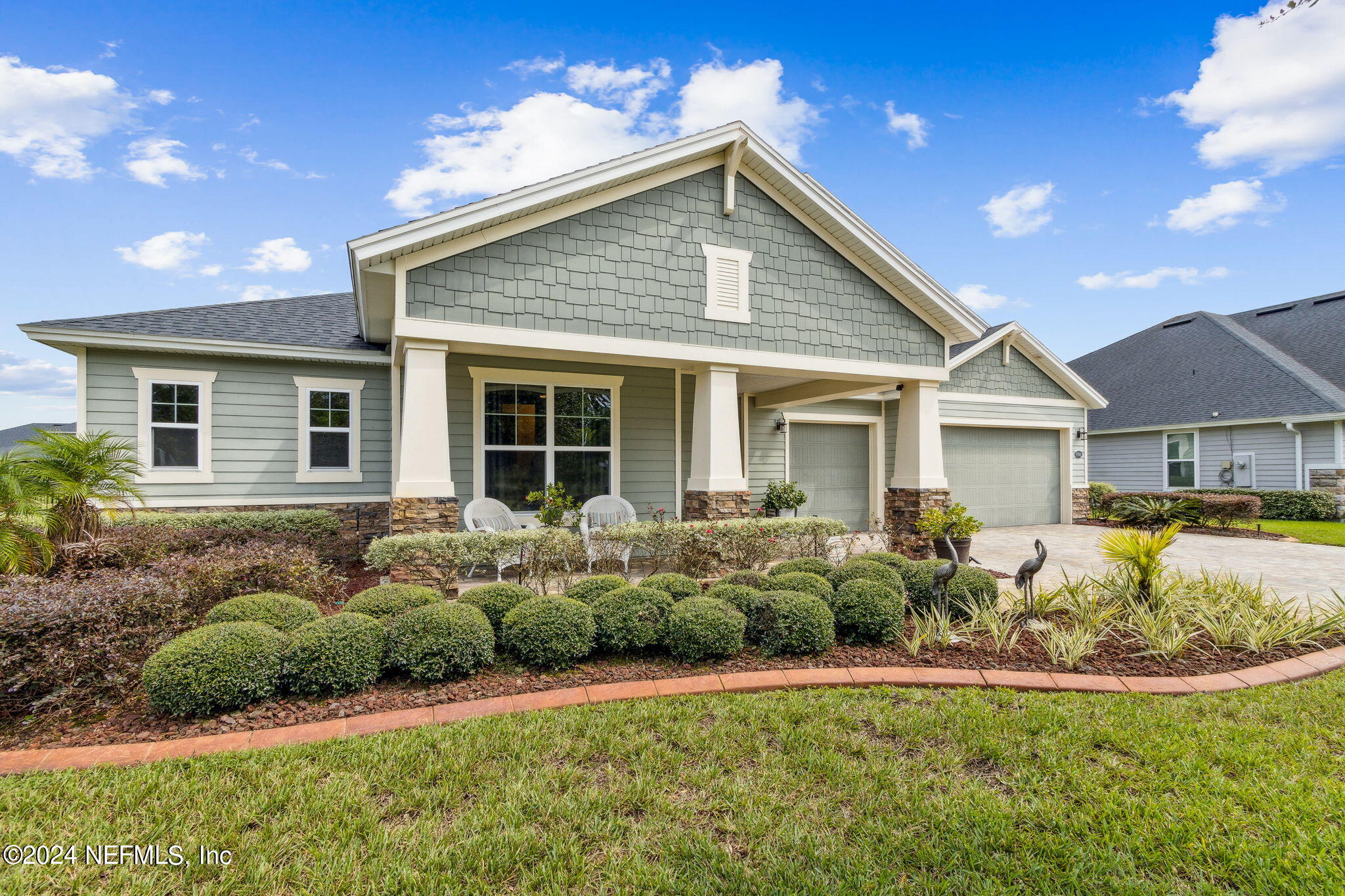 a front view of a house with a yard and potted plants