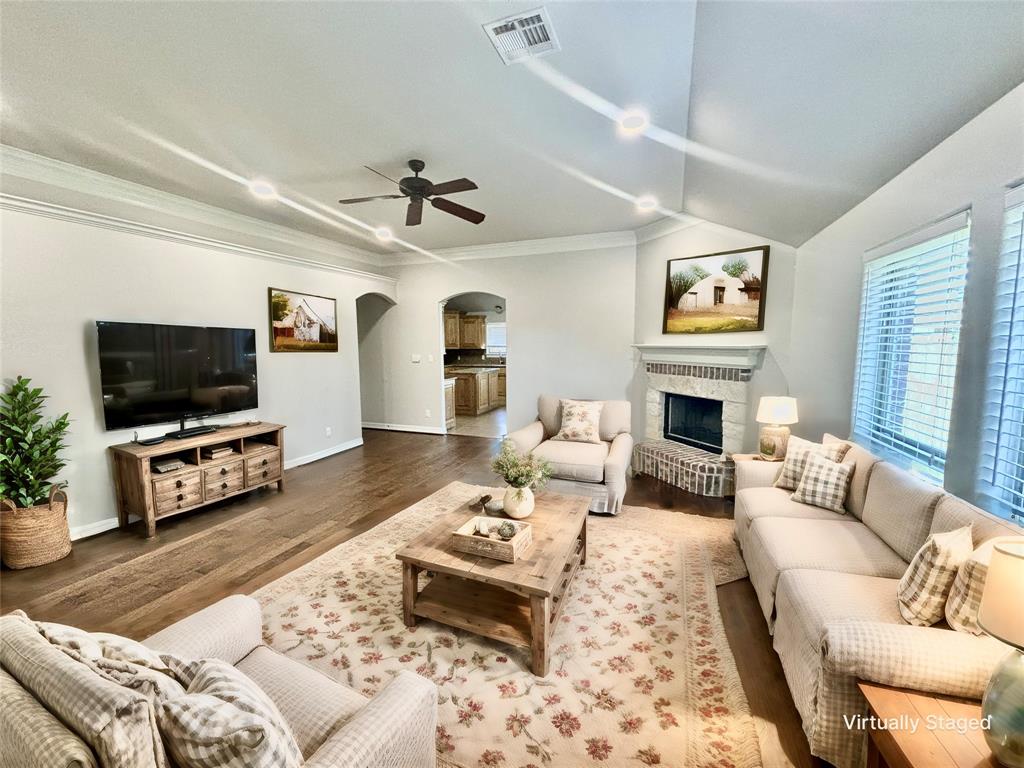 a living room with furniture a flat screen tv and a fireplace