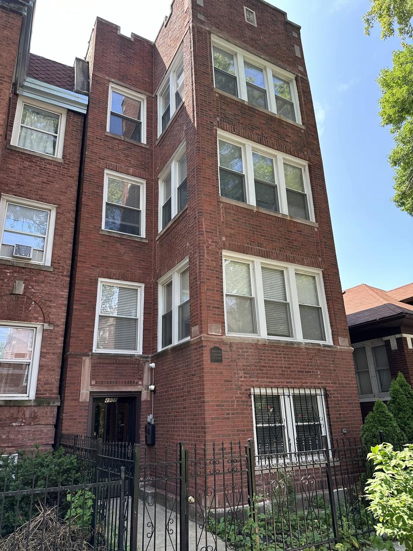 a tall building with lots of window next to a yard